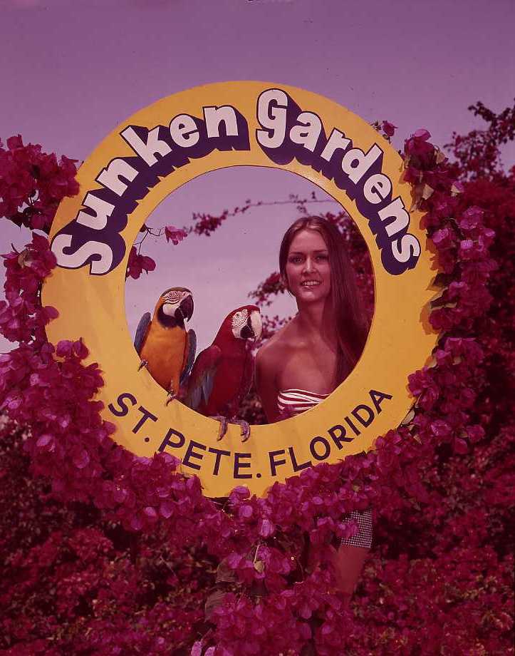photo from 1930s with girl and parrots posing inside sunken gardens frame