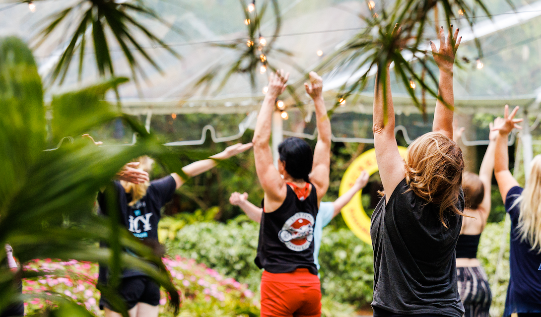 group of people stretching tall in an outdoor yoga class at Sunken Gardens