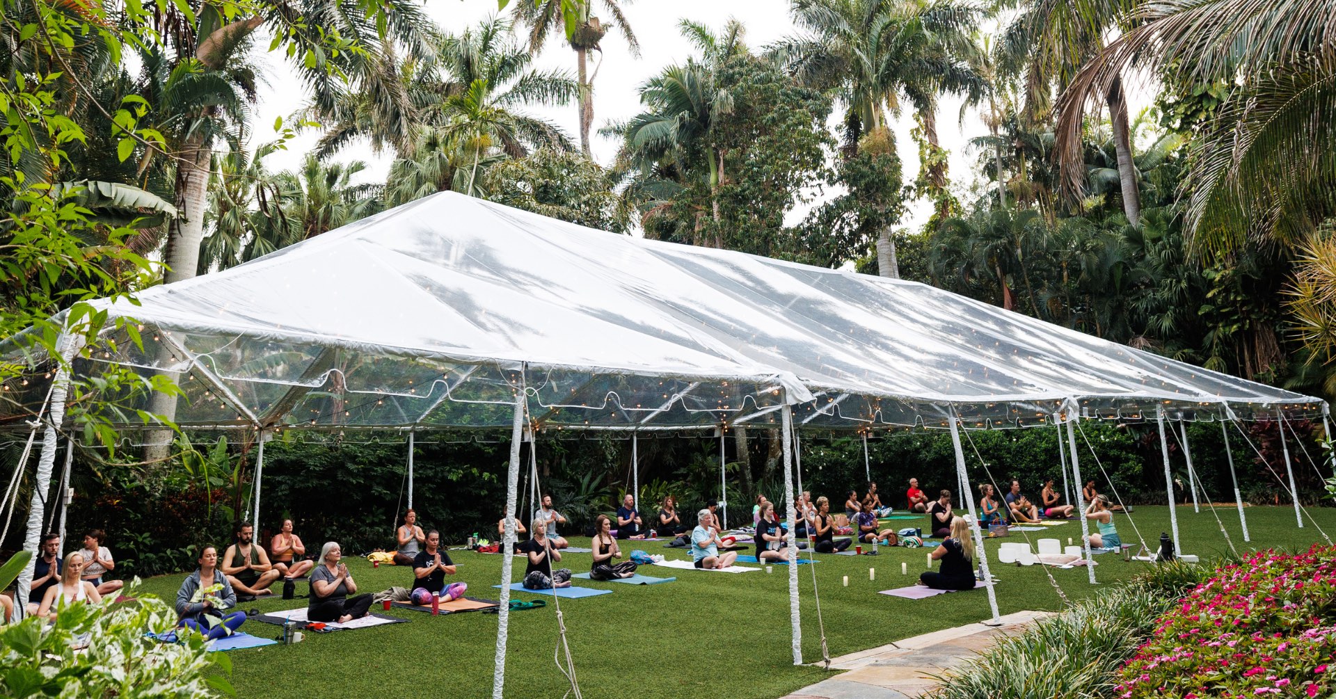 yoga class under a clear tent in the gardens